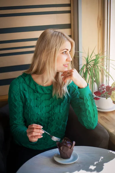 Portret van de close-up van de mooie vrouw met een chocolade muffin. — Stockfoto