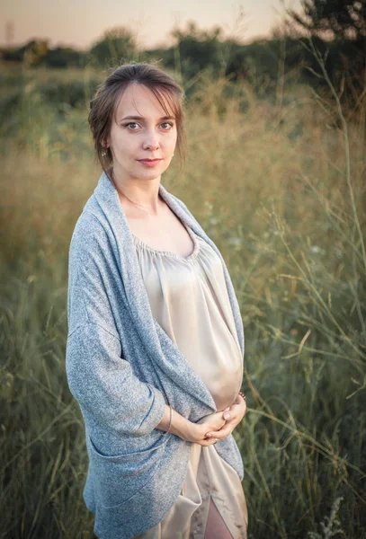 Porträtt av en ung vacker gravid kvinna på naturen. — Stockfoto