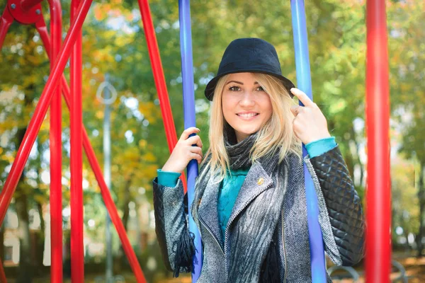 Young beautiful woman on a swing in the park. — Stock Photo, Image