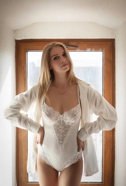 Mooie verleidelijke vrouw in ondergoed en een wit overhemd. — Stockfoto