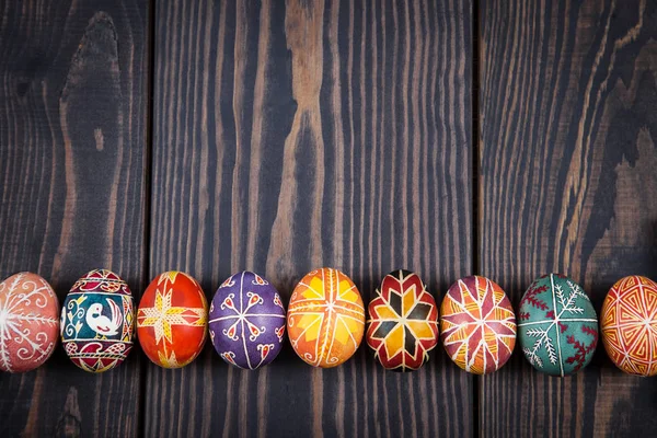 Ovos de Páscoa em uma linha no fundo de madeira escuro . — Fotografia de Stock