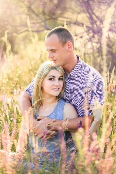 Attractive man and woman sitting on nature. — Stock Photo, Image