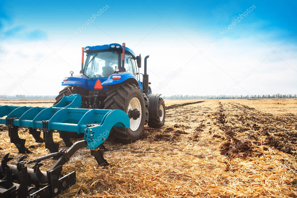 Modern tractor in the field on a sunny day.