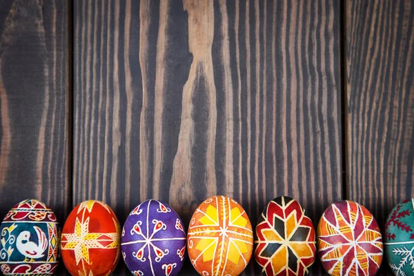 Uova di Pasqua in fila su sfondo di legno scuro . — Foto Stock