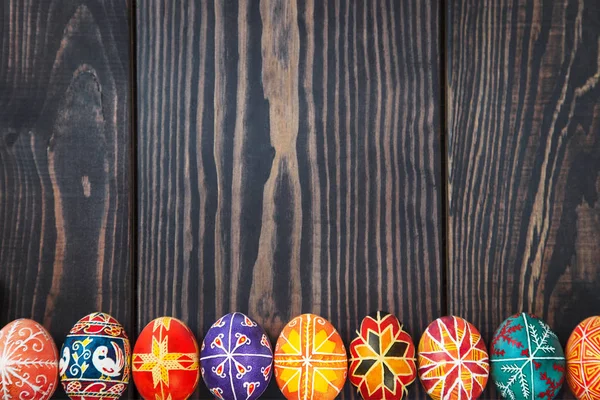 Великодні яйця поспіль на темному дерев'яному фоні . — стокове фото