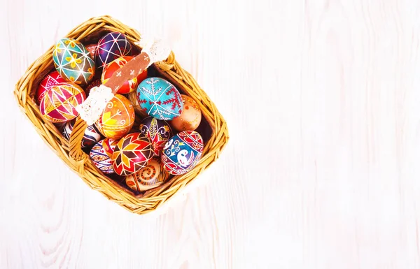 Ovos de Páscoa em uma cesta na mesa branca . — Fotografia de Stock