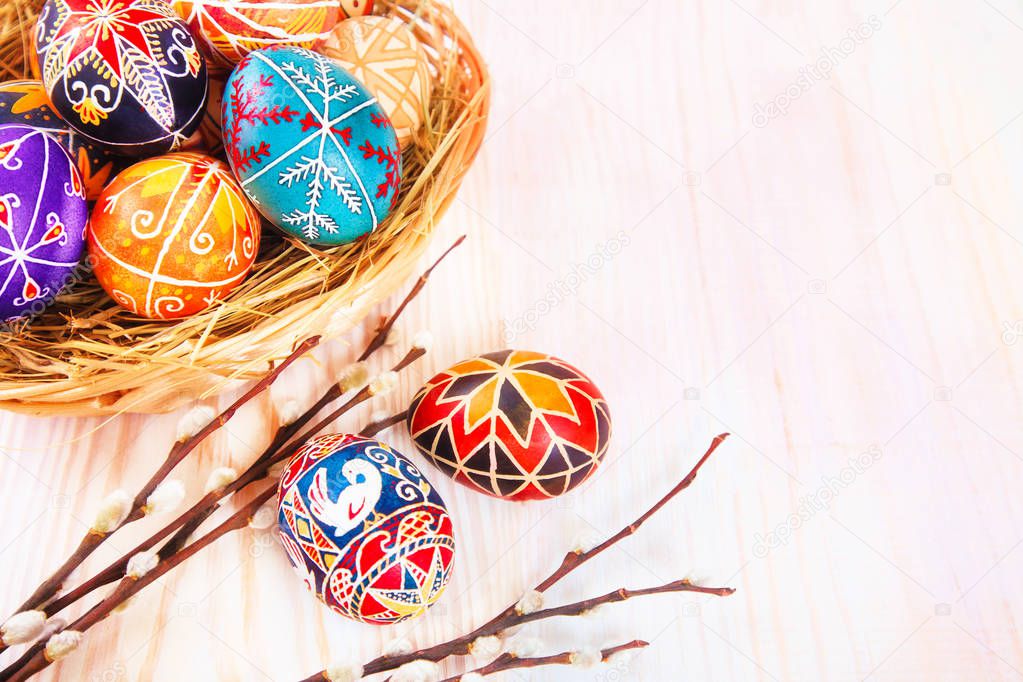 Easter eggs in a basket on white plank background.