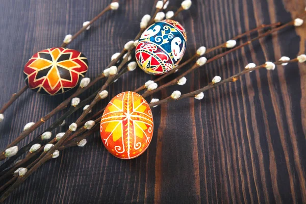 Willow dal bir ahşap tahta masada ile Paskalya yumurtaları.