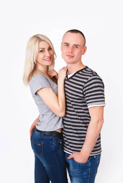 Young man and woman standing hugging in a studio. — Stock Photo, Image