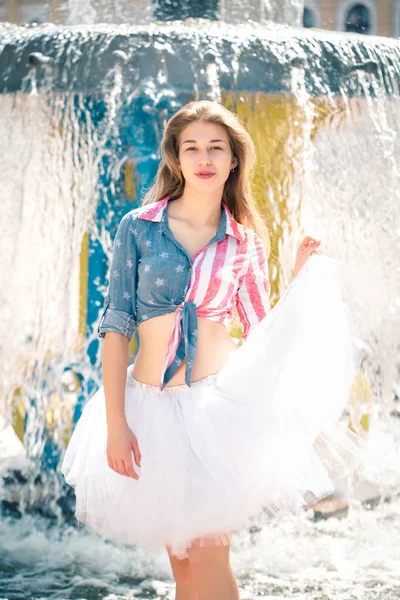 Leuke jonge vrouw in een rok in de buurt van de fontein — Stockfoto