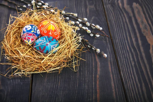 Willow twigs ahşap bir masa üzerinde bir yuva Paskalya yumurtaları.
