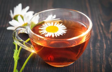 Şeffaf Kupası closeup içinde papatya çayı. Bitkisel Tıp kavramı.