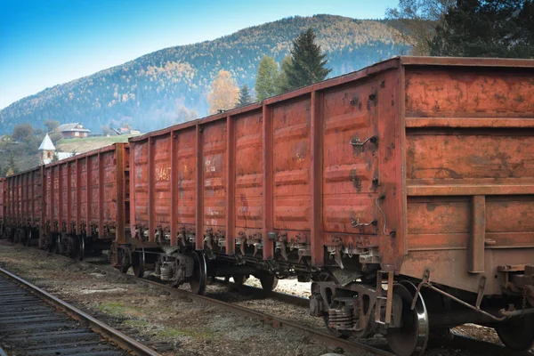 Wagons of a freight train on the railway in the mountains.