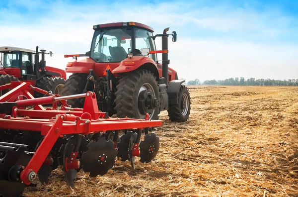 Trator vermelho no campo em um dia ensolarado brilhante . — Fotografia de Stock