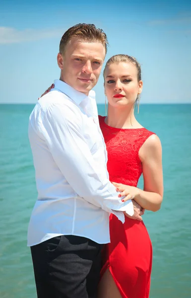 Man is hugging a woman delicatly posing with her by the sea. — Stock Photo, Image