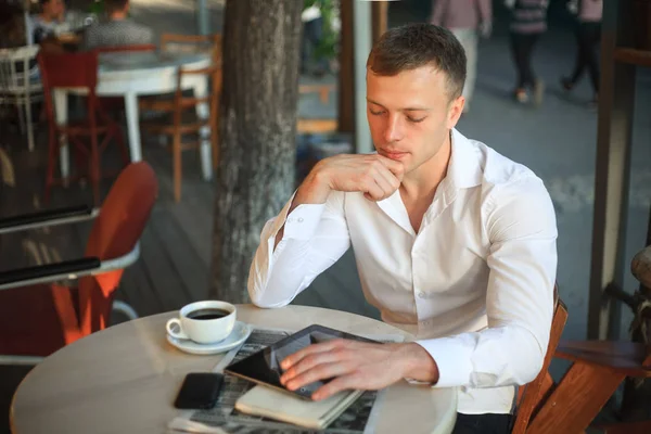 Hombre joven usando tableta digital en la cafetería de la calle . —  Fotos de Stock