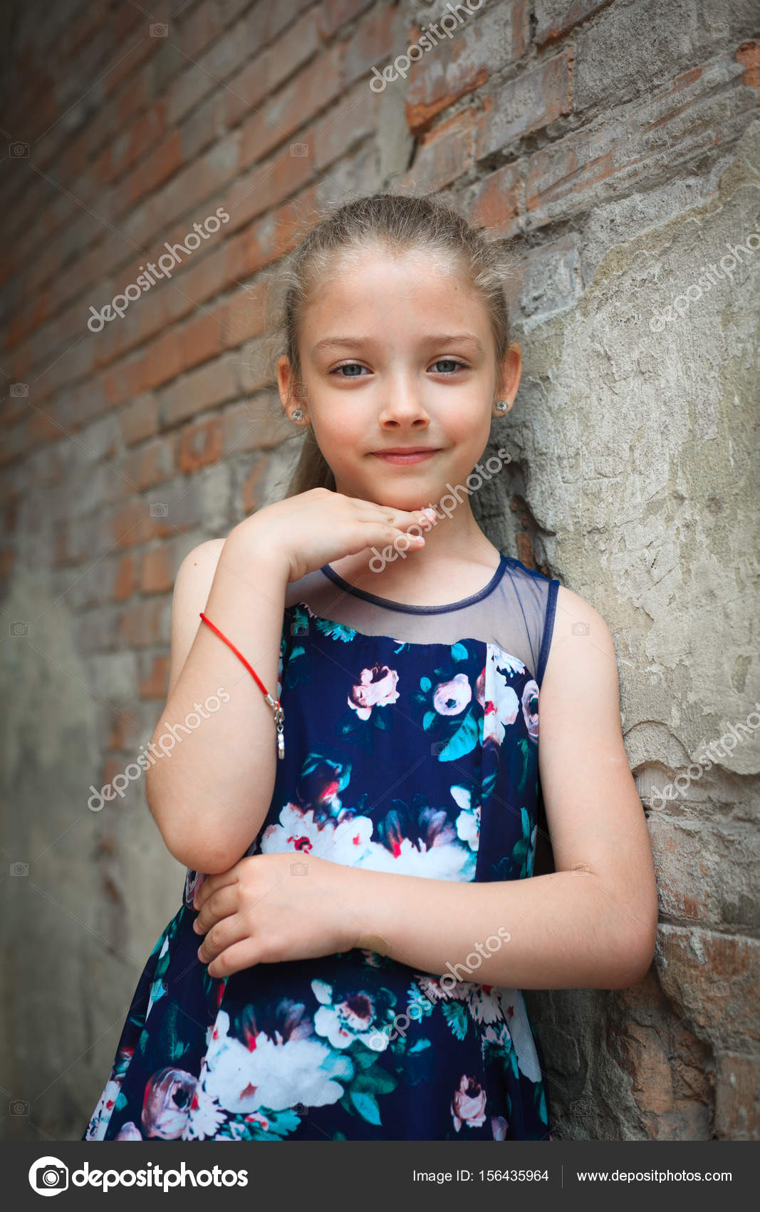 Retrato de una linda niña en edad escolar en un hermoso vestido al aire