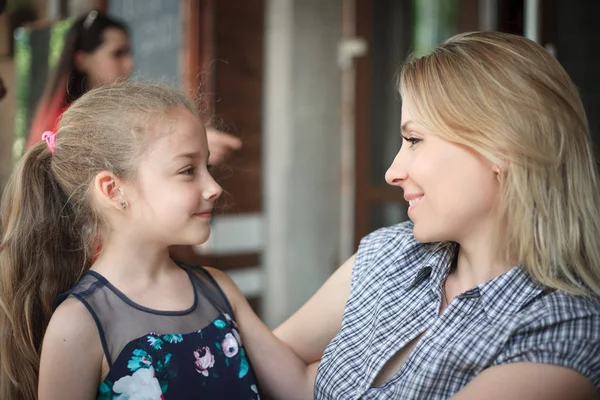 Gülümseyen genç anne ve kızı yakın çekim açık havada portre.