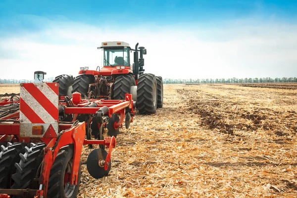 Tractor rojo en el campo en un día soleado brillante . —  Fotos de Stock