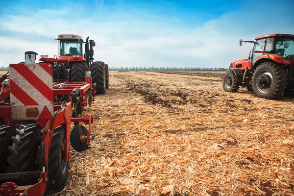 Dos tractores con un arado en un campo en un día soleado . —  Fotos de Stock