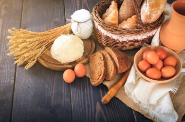 Tarım ürünleri arasında kahvaltı: yumurta, süt, ekmek ahşap bir masa üzerinde.