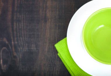 Boş levha ve ahşap masa arka plan üzerinde havlu. Yukarıdan kopya alanı ile göster