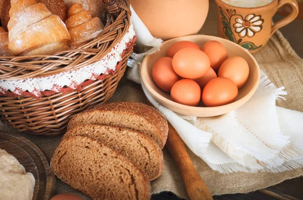 Produktów rolnych: jajka, mleko, chleb na drewnianym stole. — Zdjęcie stockowe