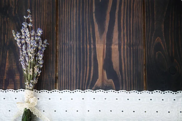 Ett gäng lavendel och spetsar på ett träbord. — Stockfoto