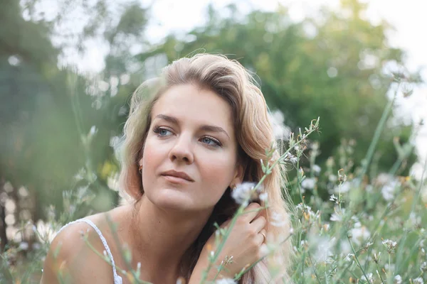 Ritratto di una giovane bella donna in un prato fiorito . — Foto Stock