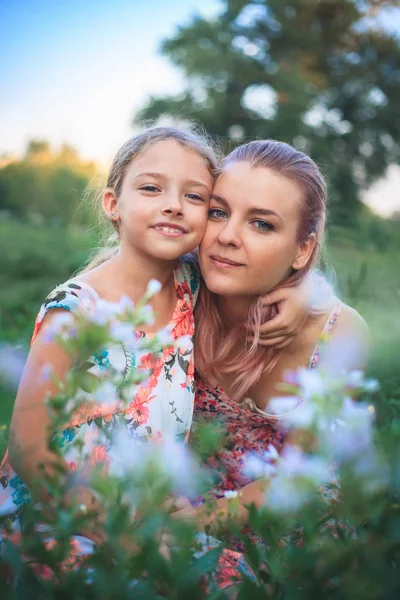 Retrato de mãe e filha na natureza em flores . — Fotografia de Stock