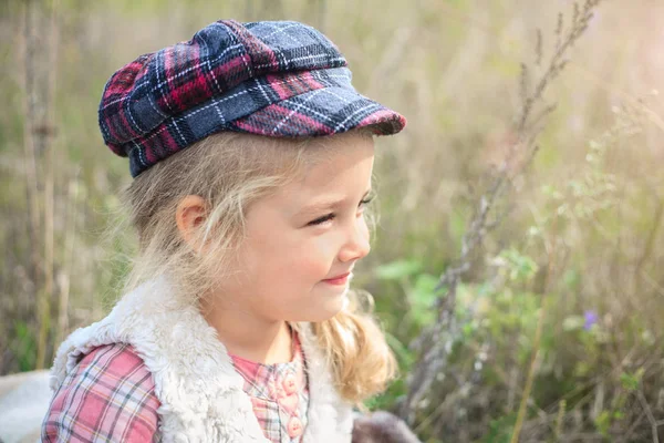 Porträtt av en söt glad liten flicka på ett natur. — Stockfoto