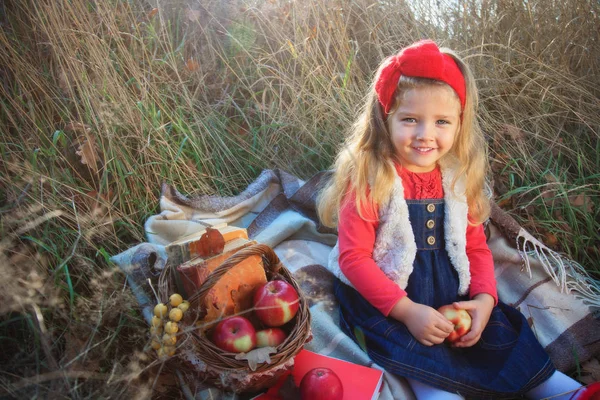 Malá holčička na přírodu s košíkem ovoce. — Stock fotografie