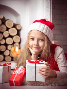 Yerde, stüdyo vurdu, vintage tarzı tonlama yatarken Noel Baba şapkalı güzel kız.