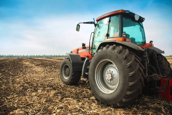 Moderní červený traktor v poli. — Stock fotografie