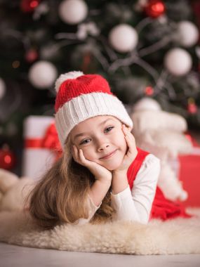 Bir Noel ağacı arka plan üzerinde sevimli küçük bir kız portresi.