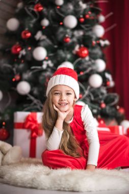 Bir Noel ağacı arka plan üzerinde sevimli küçük bir kız portresi.