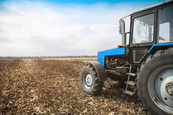 Trator azul velho em um campo vazio. Máquinas agrícolas, trabalho de campo . — Fotografia de Stock