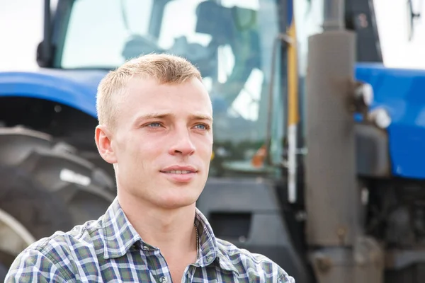 Młody mężczyzna atrakcyjny blisko ciągnika. Koncepcja rolnictwa. — Zdjęcie stockowe
