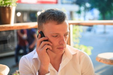 Bir telefon bir sokak kafede onun elinde olan bir adam.