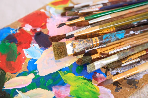 Multicolored palette and many different brushes. — Stock Photo, Image