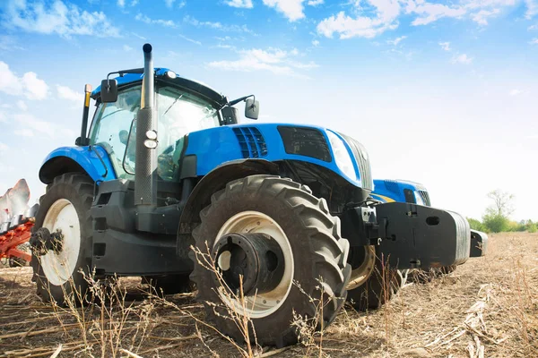Два синих трактора в пустом поле . — стоковое фото