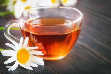 Şeffaf bir bardak papatya çayı. Bitkisel Tıp kavramı.