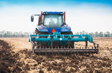 Güneşli bir alanda modern traktör.