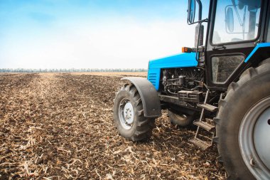 Boş bir alanda eski mavi traktör. Tarım makineleri, saha çalışması.
