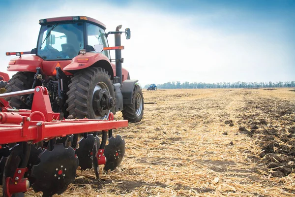 Roter Traktor auf dem Feld an einem sonnigen Tag. — Stockfoto