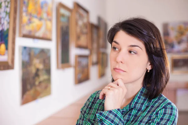 Jovem mulher olhando para a pintura . — Fotografia de Stock