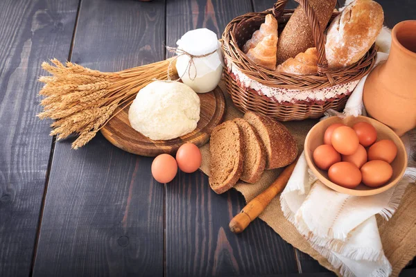 Сніданок з фермерських продуктів: яйця, молоко, хліб на дерев'яному столі . — стокове фото