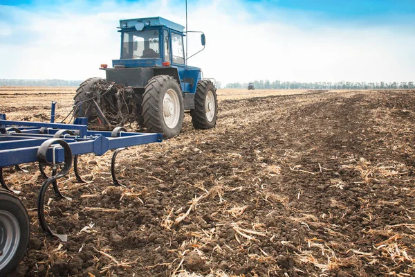 Kék traktor az a mező, egy napsütéses napon. — Stock Fotó