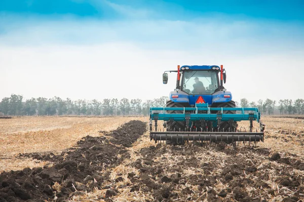 Moderne trekker in het veld op een zonnige dag. — Stockfoto