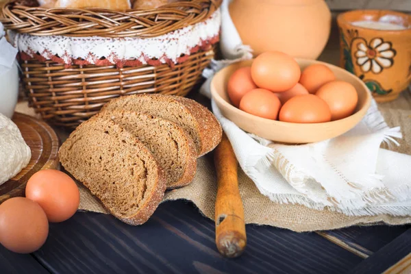 Produits de la ferme : œufs, lait, pain sur une table en bois . — Photo